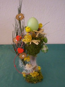 Österlich dekorierte Vase mit grüner Eierkerze zu 12.50 €.