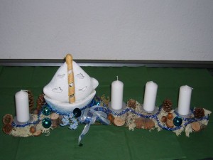 Das besondere, maritime Adventsgesteck mit Segelboot und 4 weißen Kerzen zu 10.00 €.