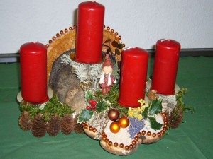 Sehr dekoratives, mittelgroßes 4er Gesteck mit roten Kerzen und verschiedenen Porlingen zu 12,00 €.