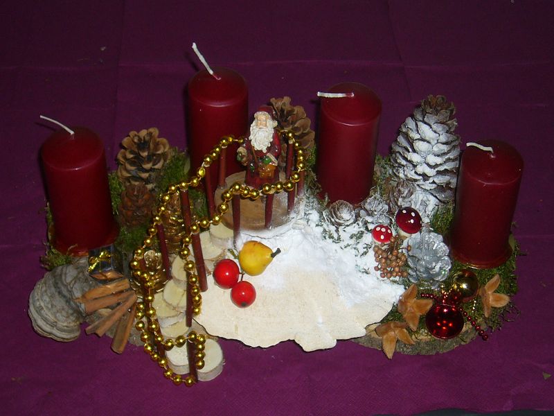 Kompakters 4er Gesteck mit dunkelroten Kerzen, ca 40 cm länge und 25 cm tiefe, Weihnachtsmann auf der Treppe, Buckel - Tramete und Schnee für 20,00 €.