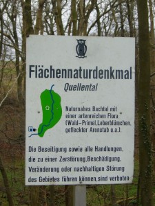 Dieses Hinweisschild macht auf einige zu beachtende Besonderheiten des Flächennaturdenkmals Glashäger Quellntal hin.