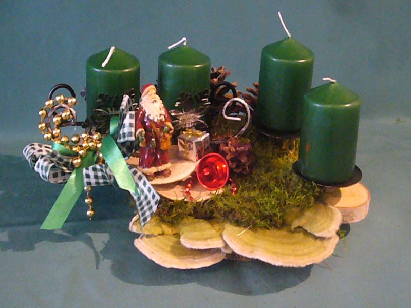 Gut 40 cm langes und 25 cm tiefes 4er Gesteck auf Baumscheibe mit grünen Stumpenkerzen, Striegelieger Tramete und Weihnachtsdekoration zu 15,00 €. 